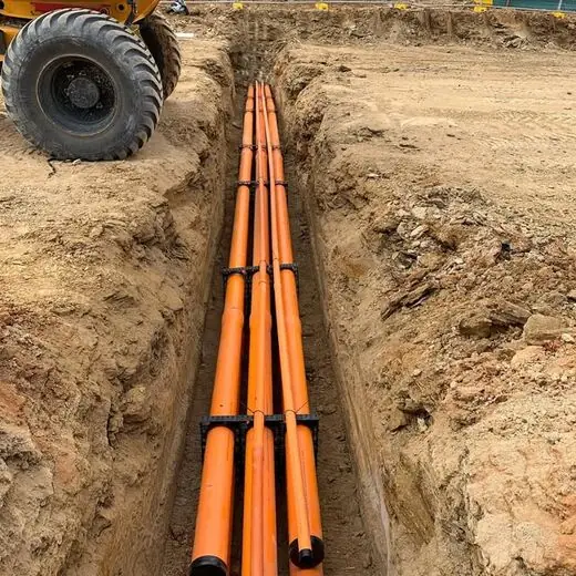 Orange conduits laid in the trench